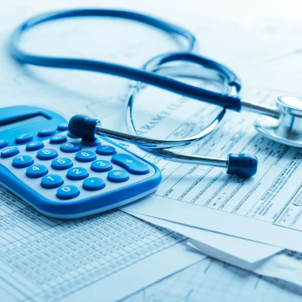 Calculadora e estetoscópio sobre formulários de plano de saúde